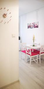 een eetkamer met een tafel en stoelen en een klok bij Diamond Apartment in Târgu-Mureş