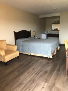 1 dormitorio con 1 cama, 1 sofá y 1 silla en Red Deer Inn & Suites en Red Deer