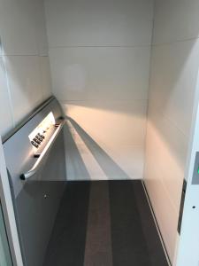 un ascensor con una estantería de cristal en una habitación en Hotel Mill Road, en Melaka