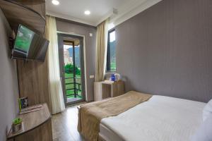 a bedroom with a bed and a flat screen tv at Suntower Hotel in Mestia