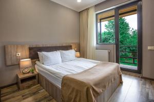 a bedroom with a large bed and a large window at Suntower Hotel in Mestia