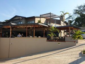 a building with people sitting outside of it at Stylish modern 2 bed apartment in Shaka's Rock in Ballito