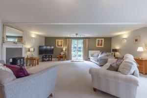 a living room with two couches and a tv at The Coach House Holiday Home in Stony Middleton