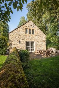 a stone house with a stone wall in front of it at The Coach House Holiday Home in Stony Middleton