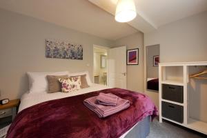 um quarto com uma cama com um cobertor roxo em Crewe Short Lets 4 Victoria Court, Crewe em Crewe