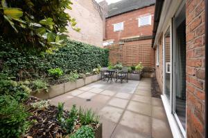 a patio with a table and chairs next to a building at Crewe Short Lets 4 Victoria Court, Crewe in Crewe