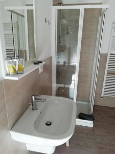 bagno con lavandino bianco e doccia di Casa Maria a Cantù