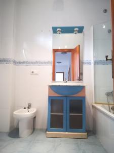 uma casa de banho com um lavatório, um WC e um espelho. em Chalk house em Tarifa