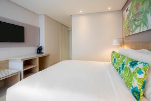 1 dormitorio con 1 cama grande y TV en Mia Hotel Choco en Quibdó