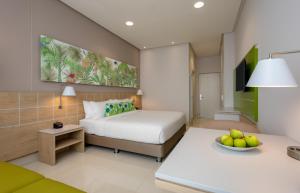 une chambre d'hôtel avec un lit et un bol de fruits sur une table dans l'établissement Mia Hotel Choco, à Quibdó