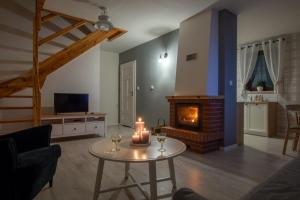 a living room with a table with candles and a fireplace at Warmia Resort in Woryty