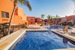 una piscina con palmeras y edificios en Cabo Cottage Authentic Mexican Design Overlooking The Beach en Cabo San Lucas