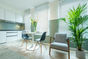 una cocina con mesa, sillas y plantas en The Card Room Green Studio en Amberes
