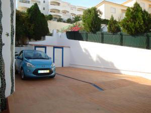un pequeño coche azul estacionado junto a un edificio en Villa Cerro, en Albufeira