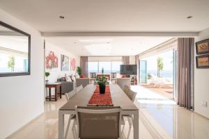 Un comedor con una mesa larga y sillas. en Funkey Villas Cape Town, en Ciudad del Cabo
