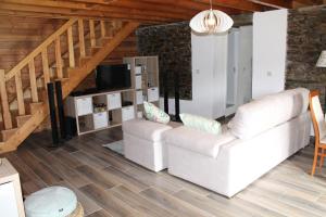 a living room with two white couches and a tv at Serapicos House in Bragança