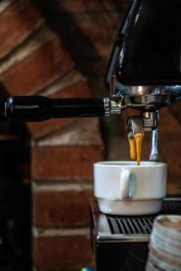 een koffiezetapparaat dat koffie in een kopje giet bij Tonito Hotel in Uyuni