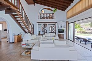 a living room with a white couch and a staircase at Casa Las Rocas in Santa Úrsula