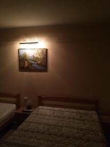 a bedroom with a bed and a painting on the wall at Djurdja Apartment in Arandjelovac
