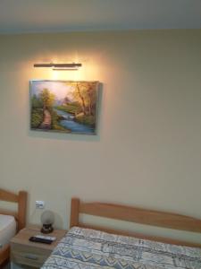 um quarto com uma cama e um quadro na parede em Djurdja Apartment em Arandjelovac
