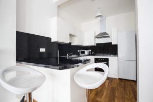 una cucina bianca con servizi igienici e lavandino di Montgomery Central Apartment a Edimburgo