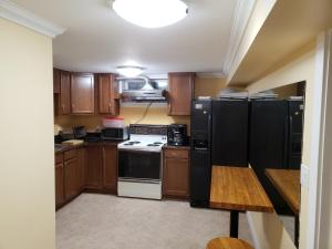 a kitchen with wooden cabinets and black appliances at Surrey chic 2 bdrm basement unit in Surrey