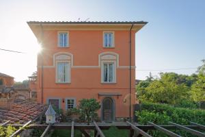 une maison orange avec le soleil derrière elle dans l'établissement Bed & Breakfast Bel Giorgio, à Orentano