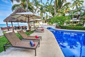 a pool with chairs and umbrellas next to the ocean at CASA KANELO in Sayulita