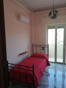 a bedroom with a bed with a red blanket at La Contessa Apartment in Palermo