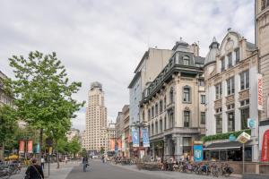 una via cittadina con edifici e persone che camminano per strada di SHWAY - The India Yellow Studio ad Anversa
