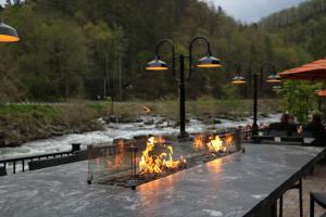 a fire pit on a table next to a river at Historic Tapoco Lodge in Tapoco