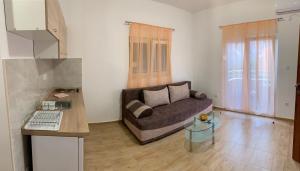a living room with a couch and a glass table at Apartmani Gaga in Tivat