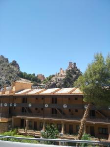 萊魯埃拉的住宿－Alojamiento Mirador del Castillo，长颈鹿站在山前的酒店