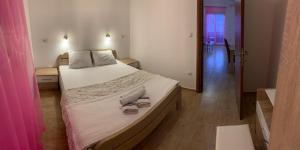 a bedroom with a large bed with shoes on it at Apartmani Gaga in Tivat