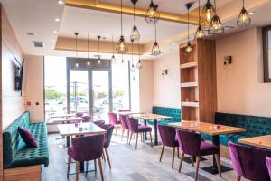Hotel Aloha في نيشْ: غرفة طعام مع طاولات وكراسي أرجوانية