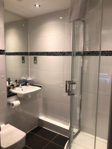 a bathroom with a shower and a sink and a toilet at Stonefield Castle Hotel ‘A Bespoke Hotel’ in Stonefield +43 photos