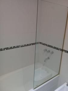 una ducha de cristal en un baño con lavabo en Veluvi, en Puerto Madryn 45 fotos más