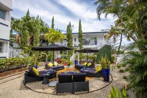 a courtyard with couches and umbrellas at Beachside All Suites Hotel in Miami Beach