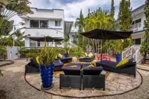 a patio with couches and umbrellas in front of a building at Beachside All Suites Hotel in Miami Beach