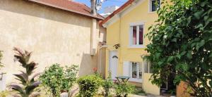 ein gelbes Haus mit einem Tisch davor in der Unterkunft La Bonbonnière in Champigny-sur-Marne