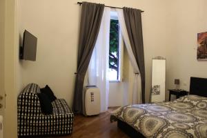 - une chambre avec un lit, une fenêtre et une chaise dans l'établissement La dimora dell’Artista, à Palerme