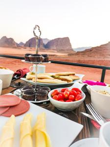 een tafel met borden en kommen met voedsel bij Zeina Desert Lodge in Wadi Rum +59 foto's