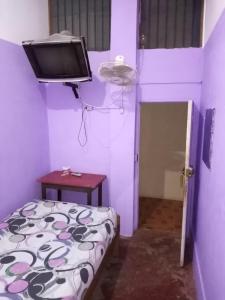 Habitación pequeña con cama y TV. en Hospedaje Independencia Pucallpa, en Pucallpa