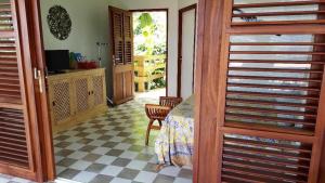 a room with a bed and a table and a door at Studio Frangipani dans Villa Fleurs des Iles in Le Vauclin