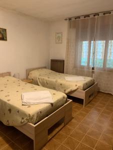 una camera da letto con due letti e una finestra di Camere Solidea a Veronella