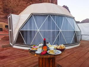 een tafel met eten voor een koepeltent bij Zeina Desert Lodge in Wadi Rum