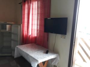 Cette chambre dispose d'une télévision et d'un banc. dans l'établissement Pisco Chalés, à Ubatuba