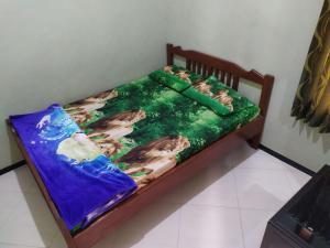 a childs bed with a mermaid blanket on it at Ijen Bondowoso Home Stay in Bondowoso