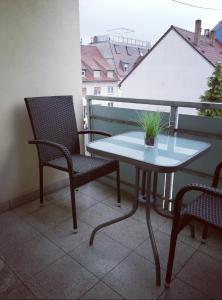 einen Tisch und zwei Stühle auf einem Balkon mit einem Tisch in der Unterkunft Albnest - Wohlfühlen in der nähe der Alb in Karlsruhe