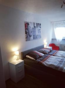 ein Schlafzimmer mit einem Bett mit zwei Lampen und einem Bild an der Wand in der Unterkunft Albnest - Wohlfühlen in der nähe der Alb in Karlsruhe
